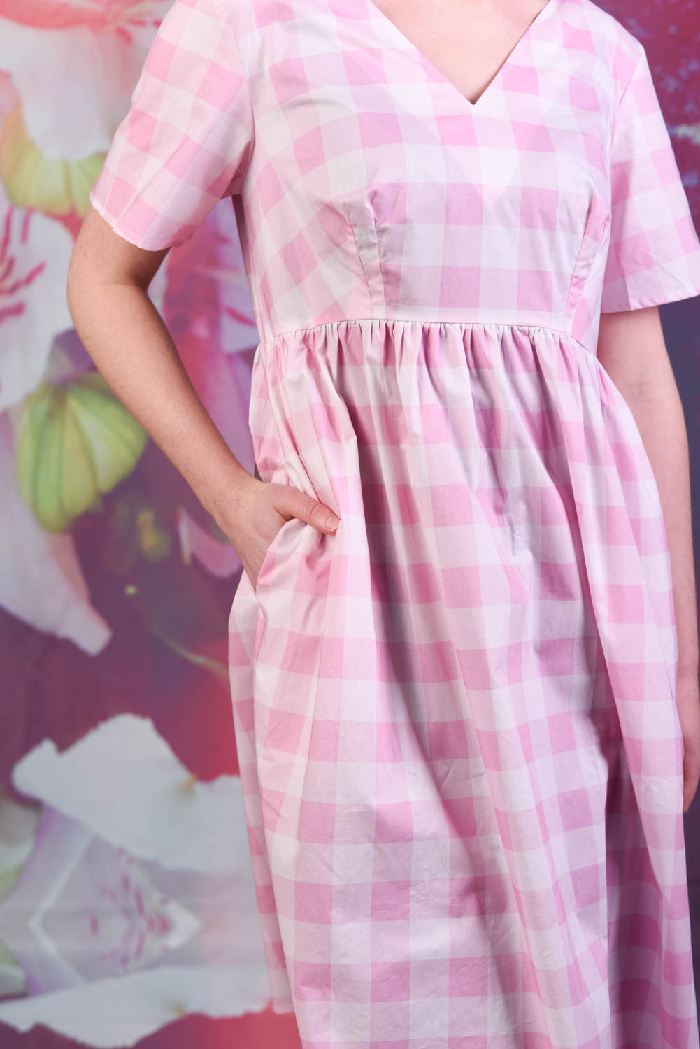 Model showing the pockets of the Annah Stretton Saski Angel Dress in pink check